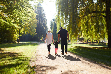 Armut in der Familie Eine junge Familie spaziert durch einen Park.