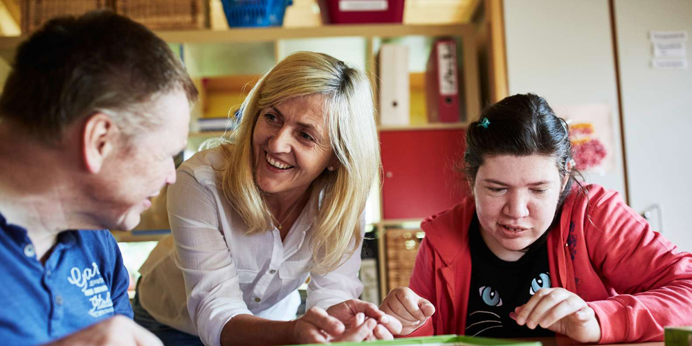 Eine Frau spricht mit einem Mann und lächelt ihn an.