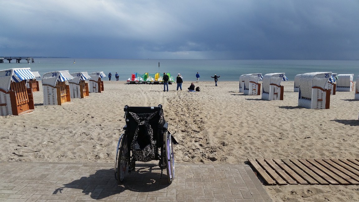 Urlaub mit Rollstuhl Ein Rollstuhl steht am Strand.
