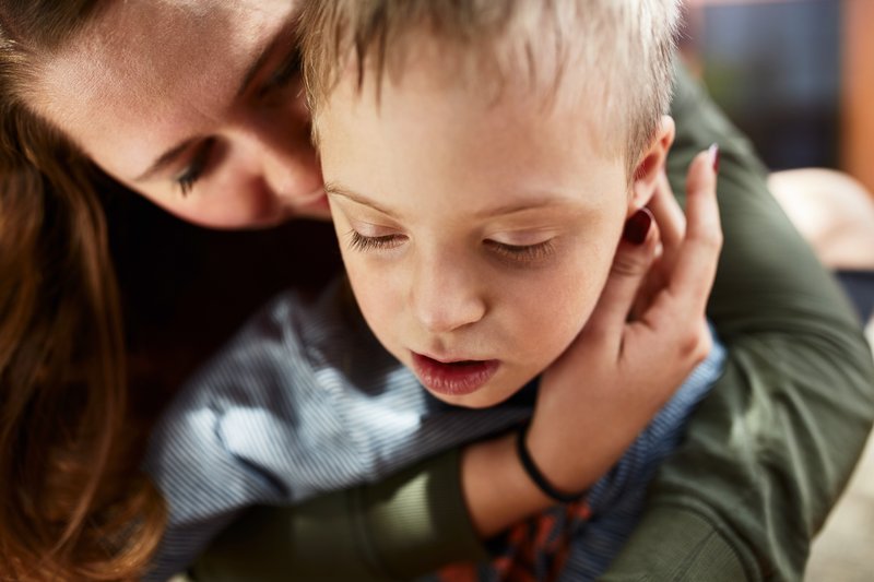 2_2_5_Herausforderndes_Verhalten Eine Mutter hält einen Jungen fest im Arm. Ein Symbolbild.