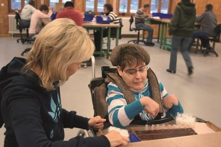 Nadine Maaß arbeitet in der Werkstatt. Nadine Maaß arbeitet in der Werkstatt. Sie sitzt im Rollstuhl.