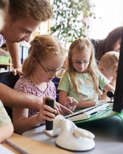 Selbsthilfegruppen zum Thema Behinderung Eine Gruppe aus Kindern vor einem Computer