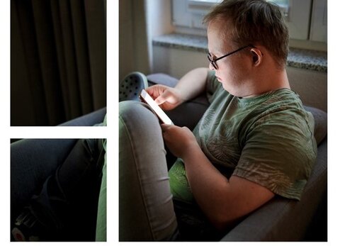 Das Buch-Cover zeigt einen jungen Mann mit Down-Syndrom, der auf sein Smartphone schaut.