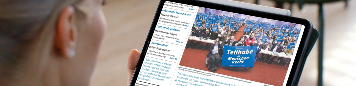 Eine junge Frau liest die Lebenshilfe Zeitung digital.