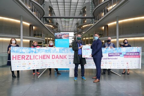 Unterschriften-Übergabe im Bundestag: Im Vordergrund Dr. Thorsten Hinz von der Initiative "Mehr wert als ein Danke" mit dem Vorsitzenden des Petitionsausschusses, Marian Wendt (rechts). Hinten von links: Barbara Heuerding, Geschäftsführerin des Bundesverbandes evangelische Behindertenhilfe, Janina Bessenich, Geschäftsführerin der Caritas Behindertenhilfe und Psychiatrie (CBP), Prof. Dr. Jeanne Nicklas-Faust, Bundesgeschäftsführerin der Lebenshilfe, Wilfried Gaul-Canjé, Geschäftsführer der St. Augustinus-Behindertenhilfe in Neuss und CBP-Vorstand, sowie Kerstin Kassner, MdB. Unten gibt es das Bild als druckfähigen und honorarfreien Download.