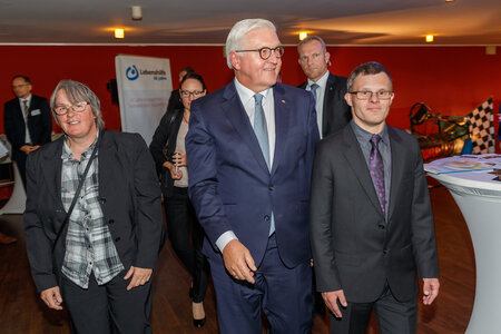 Das Bild zeigt Bundespräsident Frank-Walter Steinmeier (Mitte) mit Ramona Günther, Selbstvertreterin mit Behinderung im Bundesvorstand der Lebenshilfe, und Moderator Sebastian Urbanski im Café Auster.