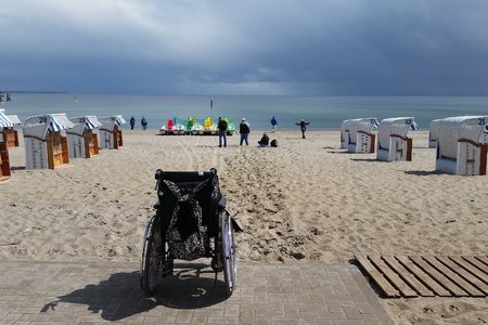 Ein Rollstuhl steht am Strand. 