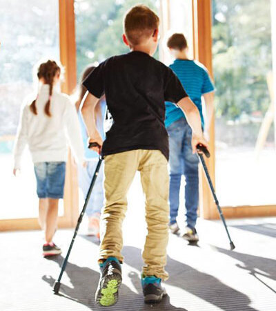 Ein Junge mit Beeinträchtigung folgt anderen Kindern nach draußen.