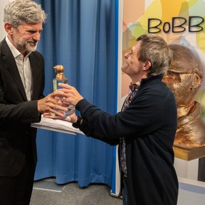 Sebastian Urbanski (rechts), Bundesvorstandsmitglied der Lebenshilfe, überreicht Florian Jaenicke den BOBBY-Preis.