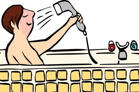 Ein Mann sitzt in der Badewanne und duscht sich.