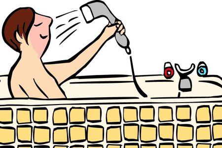 Ein Mann sitzt in der Badewanne und duscht sich.
