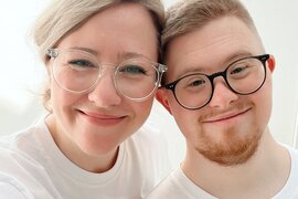 Die Geschwister Marian und Tabea Mewes lächeln in die Kamera. Beide tragen eine Brille.