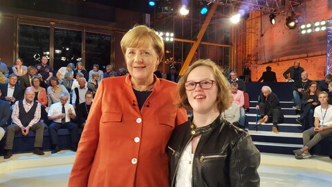 Natalie Dedreux (rechts) und Bundeskanzlerin Angela Merkel stehen nebeneinander in der ARD-Sendung Wahlarena. Im Hintergrund ist das Studio-Publikum.