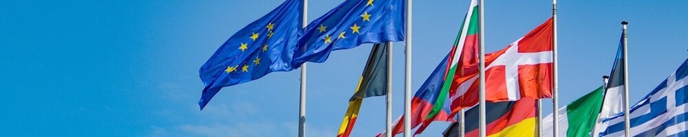 Die EU-Flagge sowie weitere Flaggen der Mitgliedsstaaten wehen im Wind.