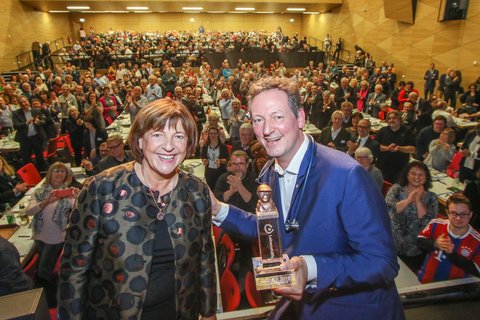 Dr. Eckart von Hirschhausen mit Ulla Schmidt auf der Bühne der Marburger Stadthalle. Hinter ihnen sind applaudierende Lebenshilfe-Delegierte zu sehen. 