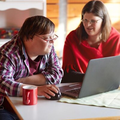 Eine Frau und ein Mann arbeiten zusammen am Laptop