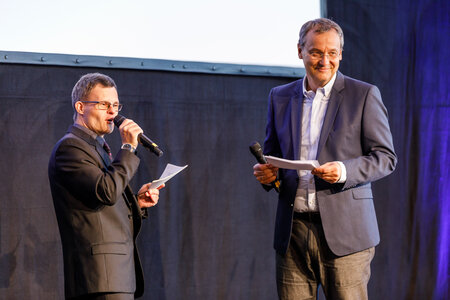 Das Bild zeigt das Moderatoren-Duo Sebastian Urbanski und Knut Elstermann auf der Bühne des Café Auster. 